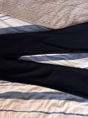 Svarta leggings från H&M Move - Snygga svarta leggings från H&M Move i storlek M. De har en hög midja och är tillverkade i ett stretchigt material som sitter skönt och följsamt. Perfekta för träning eller en aktiv vardag. Klassisk och stilren design utan synliga detaljer.