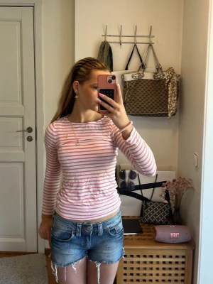 Blå jeansshorts med fransar - Snygga blå jeansshorts med slitna detaljer och fransar nertill. Klassisk femficksmodell med knapp och dragkedja framtill. Perfekta för varma dagar och enkel att matcha med olika toppar.