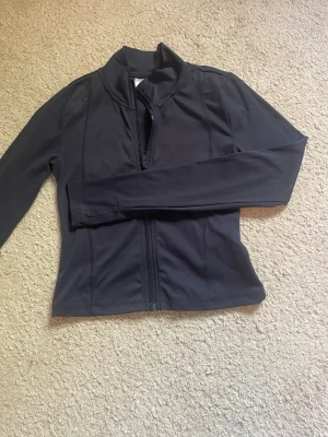 Mörkblått set i sportigt material - Mörkblått set i sportigt/stretchigt material från Gina tricot. Jackan är i bra skick men lite noppig på ryggen. Byxorna är i bra skick. Säljer pga att det är för litet. Strl 146/152.