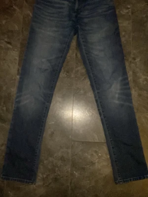 Hugo boss slim fit jeans - Snygga mörkblå slim fit jeans med lätt slitna detaljer på låren och knäna. Jeansen har klassisk femficksdesign och raka ben. Perfekta för en trendig och avslappnad look.