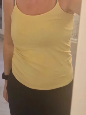 Gul linne - Snyggt gult linne med smala axelband och rundad halsringning. Linnet är perfekt för en avslappnad look. Passar till jeans eller shorts för en enkel stil. Skriv vid intresse.💛