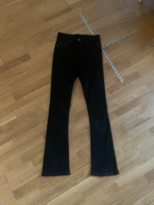 Svarta bootcut jeans - Säljer ett par svarta bootcut jeans med klassisk femficksdesign och hög midja. Jeansen har en smal passform upptill och lätt utsvängda ben.            Helt oanvända och nyköpta men dom passade it mig i storleken.
