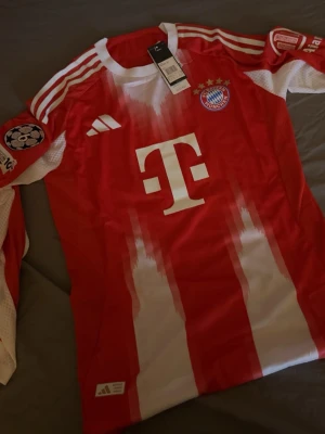 Bayern München matchtröja Olise 17 - Bayern Münchens långärmad tröja med UCL loggan på och dessutom är den spelarversion så den funkar allmänt ganska bra under sommaren, våren och hösten. Mycket värt att köpa 