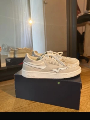 Reebok skor / Sneakers - Reebok Club C Revenge Tennis skor. Knappt använda. Original kartong medföljer.   Har tvättat av undersidan, men inte använt skottvätt på skorna så går säkert att få helt rena.   Dem är vita och kallt beiga.  Storlek 38.5.