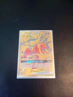 Pokémonkort Reshiram & Charizard GX - Säljer ett Pokémonkort med Reshiram & Charizard GX TAG TEAM. Kortet har en guldfärgad framsida med holografiska detaljer och tydliga illustrationer av båda Pokémon. Perfekt för samlare! Fraktas i plastfodral. Skrapig yta.
