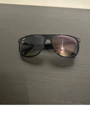 Svarta Ray-Ban pilotbågar solglasögon - Snygga svarta solglasögon från Ray-Ban i klassisk pilotmodell. Bågarna är svarta med mörka glas och har en stilren design som passar till de flesta outfits. Perfekta för dig som vill ha en tidlös och cool look.