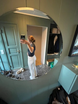 Vita prickiga leggings med utsvängda ben - Säljer ett par vita leggings med små svarta prickar och utsvängda ben. De har hög midja och sitter tajt över höfterna. Perfekta för dig som gillar en trendig och bekväm stil. Materialet känns mjukt och stretchigt.