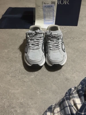 Fin skor - Snygga grå  sneakers med mesh och läderdetaljer samt tydlig cd-logga på sidan. Skorna har en chunky sula och klassisk snörning. Perfekta för dig som gillar exklusiva och trendiga sneakers med sportig vibe.