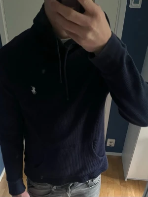 Mörkblå hoodie Ralph Lauren - Säljer en mörkblå hoodie från Polo Ralph. Bara fråga vid funderingar. Kan gå ned i pris vid snabb affär. Storlek M men passar mer som S
