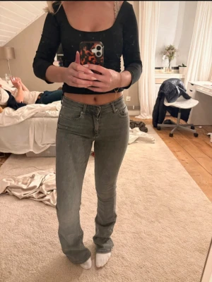Grå raka jeans med hög midja - Säljer ett par grå jeans med raka ben och hög midja. Jeansen har klassisk femficksdesign och stängs med dragkedja och knapp. Snygg passform som sitter tajt upptill och släpper vid benen. Perfekta till crop tops eller hoodies.