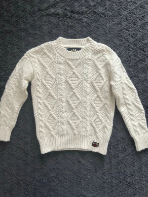 Superdry stickad tröja - En fet stickad tröja från märket superdry. Den är nästintill aldrig använd och i perfekt skick 9,7/10✅. Den är i storlek xs. Hör av dig om du har några frågor.