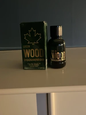 Dsquared2 Green Wood Eau de Toilette -  Green Wood från Dsquared2 är en Eau de Toilette för män med en mörkgrön glasflaska och matchande kartong. Flaskan har en stilren, rund form och guldfärgad text. Doften har träiga och fräscha inslag, perfekt för dig som gillar maskulina parfymer.   Finns typ 80% av flaskan kvar 