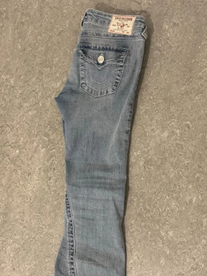 True Religion Low Rise Jeans - Säljer ett par true religion jeans i modellen joey, köptes för 1299kr. Säljer pågrund av att den inte passar längre, byxorna är ÄNDAST använda 3 gånger. OBS:Byxorna är uppsydda och passar perfekt på någon som är 158-163cm