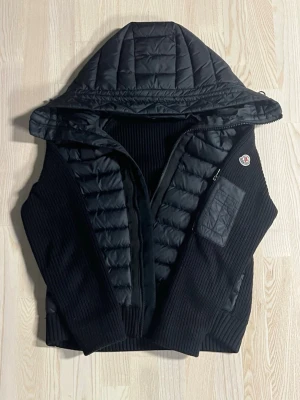 Moncler Cardigan  - Säljer en svart Moncler cardigan i storlek S i jättefint skick! 🔥   Den är sparsamt använd och ser i princip ut som ny – inga fläckar, noppor eller tecken på slitage.  Cardiganen är 100% äkta och av hög kvalitet, precis som man förväntar sig av Moncler. Passar perfekt både till vardag och när du vill vara lite mer uppklädd.  Vill bli av med den snabbt, så smidig affär prioriteras! 💨   Först till kvarn gäller – hör av dig vid intresse eller om du vill ha fler bilder!