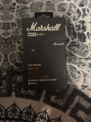 Marshall Motif A.N.C. trådlösa hörlurar - Marshall Motif A.N.C. true wireless in-ear hörlurar med aktiv brusreducering och upp till 20 timmars batteritid. Svart design med klassisk Marshall-logga och laddningsetui i läderliknande material. Bluetooth-anslutning för smidig användning.
