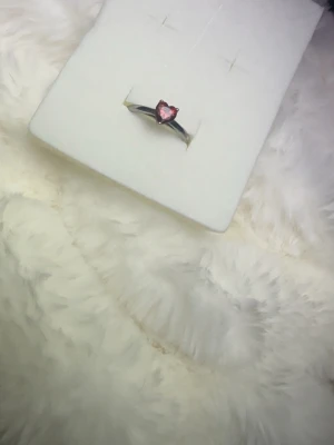Silverring med hjärtformad röd sten - Snygg silverfärgad ring med en hjärtformad röd sten i mitten. Ringen har en enkel och stilren design som gör att den sticker ut utan att bli för mycket. Perfekt för dig som gillar romantiska detaljer och vill ha något unikt på fingret. 