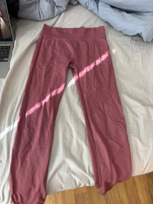 Rosa sömlösa leggings  - Säljer ett par rosa sömlösa leggings med ribbad kant. De är stretchiga och sitter tight, perfekta för träning eller chill. Materialet känns mjukt och följsamt mot huden. Inga synliga loggor eller märken.