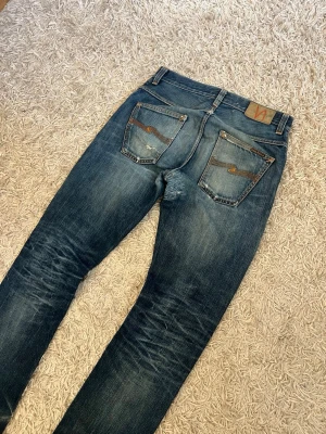Nudie jeans fearless freddie w29 wash fade archive denim  - Nudie jeans i modell fearless freddie med slim straight passform. Sjukt najs fade med snygga slitningar/lagningar och honeycombs. Storlek 29/32 passar även 30/32. Trasiga framfickor som kan lagas gratis hos nudie butiken om man vill använda dem. Postas antigen samma dag som köp eller dagen därpå💯🙌