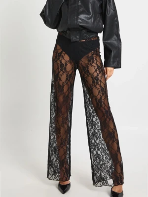 Svarta transparenta spetsleggings - Säljer ett par svarta leggings i transparent spets med blommönster. De har hög midja och vida ben för en trendig look. Perfekta för dig som vill sticka ut och skapa en edgy outfit.