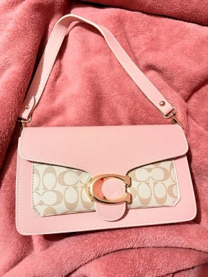  rosa axelremsväska - Snygg axelremsväska i ljusrosa läder med beige canvasdetaljer. Väskan är aldrig använd. 