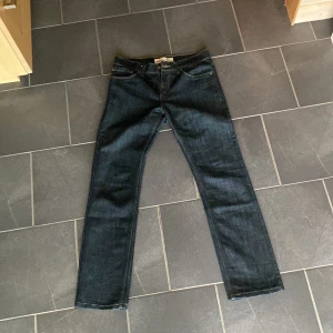 Levi's 511 Slim mörkblå jeans W29 L29 - Snygga Levi's 511 Slim jeans i mörkblå tvätt med klassisk femficksdesign. Jeansen har smal passform och raka ben, tillverkade i en mix av bomull och polyester för skön stretch och hållbarhet. Perfekta för dig som gillar en clean och stilren look. Pris kan diskuteras