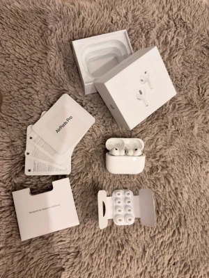 AirPods Pro 3 2025 - Säljer ett par vita Apple AirPods Pro 3 med laddningsetui och extra silikonpluggar. Hörlurarna är trådlösa och levereras i originalförpackning med manualer och tillbehör. Snygg och stilren design i plast, perfekt för dig som vill ha grymt ljud och smidig användning.