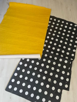 Vaxduk svart prickigt & gult flanell med baksida  - Vaxduk , en svart med stora vita prickar och en enfärgad gul. Perfekt på bord Gul flanell duk med baksida att gädtss ass på bord  Materialet känns som eller polyesterblandning. Säljes tillsammans.  Några fläckar på det prickiga enligt bild 