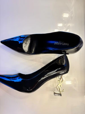 Klackskor - OBS EJ RÄTT STORLEK, läs . Supersnygga svarta klackskor med guldig klack som är formad som YSL. Tyvärr alldeles för små för mig. Märkta 42 men flera storlekar mindre. Hela innermått är ca 27,5cm men passar någon med ca 24,5-26cm fot pga modellen. (Strl 39/40?) Utgå infrån cm måttet och utifrån vilken passform du önskar. Klackhöjd ~8cm. Säljs utan kvitto. Skriv gärna för hjälp med storleken om det skulle behövas🩷