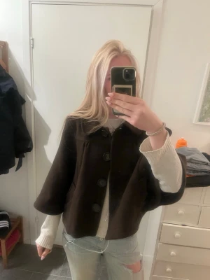 Mörkbrun poncho liknande kappa - Jättesöt mörkbrun poncho med stora knappar, perfekt till våren!