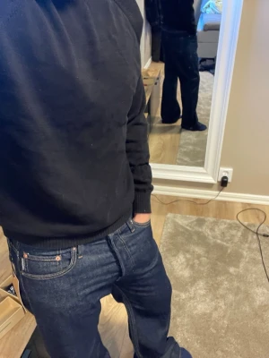 Mörkblå jeans från Jack & Jones - Säljer ett par mörkblå jeans från Jack & Jones med klassisk femficksmodell och raka ben. Jeansen har snygga kontrastsömmar och är tillverkade i slitstark denim. Perfekta för dig som gillar en tidlös och enkel sti, byxorna har ej använts.