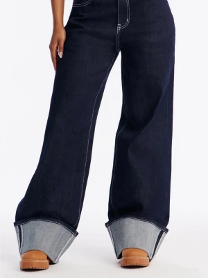 Mörkblå wide leg jeans med uppvik - Säljer ett par mörkblå jeans med riktigt breda ben och stora uppvik nertill. Jeansen har kontrastsömmar och klassiska bakfickor. Perfekta för dig som gillar en oversized och trendig look. Materialet är kraftig denim i bomull.