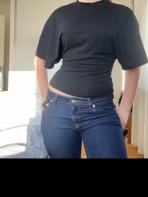 Svart croppad topp med vida ärmar - Säljer en svart croppad topp från gina med vida, korta ärmar och rund hals. Toppen har en tight passform i midjan och är gjord i mjuk bomull. Storlek:XXS