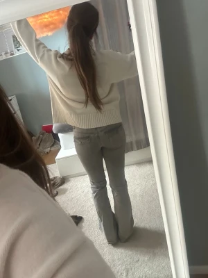 Gråa bootcut jeans - Säljer ett par gråa bootcut jeans med hög midja och klassisk femficksdesign. Jeansen har en snygg tvättad look och är i ett mjukt denimtyg som sitter bekvämt. Perfekta för dig som gillar en avslappnad men trendig stil.