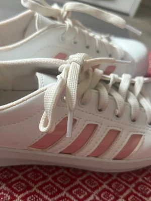 Adidas sneakers vit/rosa – stl 37 🤍💗 - Superfina vita Adidas sneakers med rosa ränder i stl 37. Endast använda ca 2 gånger!  Väldigt fint skick – bara små, normala tecken på användning på sulan baktill. Ingen originalkartong  Perfekta till vår/sommar och passar till nästan allt 🌸 