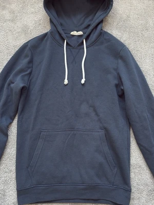 Mörkblå hoodie med vita snören - En stilren och klassiskt hoodie från Pier one. Väldigt skön passform och storlek S. Använd 2 gånger och säljer den för endast 99kr. Hör av dig vid fler frågor eller funderingar 