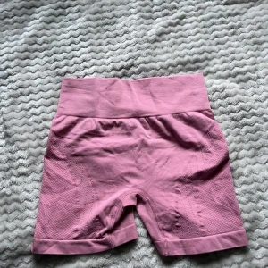 Rosa träningsshorts  - Säljer ett par rosa träningstights shorts med hög midja. De har ribbad linning och diskret struktur i materialet för extra komfort och passform. Perfekta för gymmet eller andra träningspass.💛Finns tyvärr ingen lapp. 