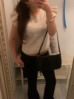 Beige stickad topp med volangärmar - Supersöt beige stickad topp med volangärmar och ribbad rund hals. Supersnygg och endast använd någon gång. Säljer då jag tyvärr inte har användning för den. Den är i stolek 158-164 men passar som s för materialet är väldigt stretchigt. Pris kan diskuteras 💕💕