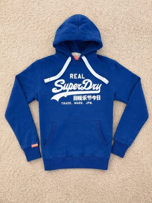 Superdry Hoodie - Snygg blå hoodie från Superdry. - Eftertraktad Colourway och svår att få tag på. - Storlek: M men sitter närmare S enligt mig. - Pris: 599kr - Först till Kvarn! 