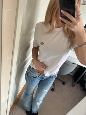 Vit t-shirt från Dickies - Säljer en klassisk vit t-shirt från Dickies med liten broderad logga på bröstet. T-shirten har rund halsringning och korta ärmar. Perfekt basic-plagg som funkar till allt och är gjord i mjuk bomull för skön känsla.🥰🤩