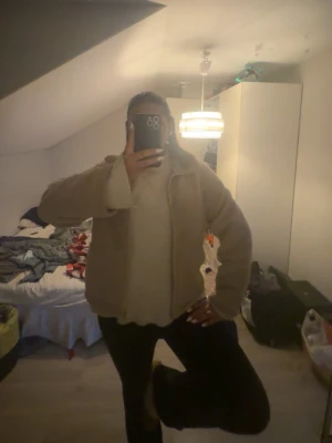 Beige teddyjacka med dragkedja - Säljer en beige teddyjacka med dragkedja framtill och hög krage. Jackan har en oversized passform och är gjord i mjukt, fluffigt material som ger en riktigt cozy vibe. Perfekt för kyliga dagar när du vill vara både varm och stylish.