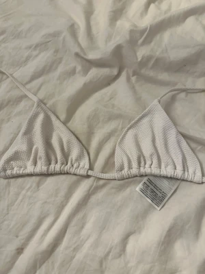 Bikini överdel - Säljer en vit triangel bikini överdel med ribbat mönster, perfekt till sommarn!