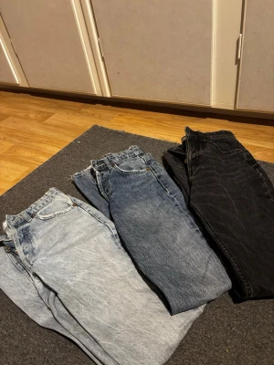 Tre par mid rise jeans  - Säljer tre par jeans i olika tvättar: ett par ljusblå, ett par mellanblå och ett par svartgrå. Alla har raka ben. Perfekt för dig som gillar tidlös stil och variation i garderoben.