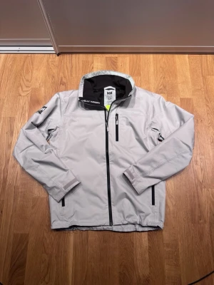 Helly Hansen jacka - Snygg vit Helly Hansen jacka i storlek S i väldigt bra skick. Jackan har en hög krage och är perfekt till blåsiga dagar. Hör av dig om du har någon fråga!