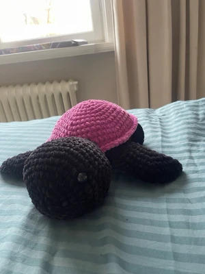Virkad sköldpaddsmjukis rosa och svart - Supergullig handvirkad sköldpadda i mjukt garn. Perfekt som dekoration eller gosedjur. Tillverkad i tjockt, fluffigt garn som ger en mysig känsla.