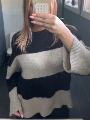 Stickad tröja - Randig svart beige stickad tröja. Knappt använd💕.