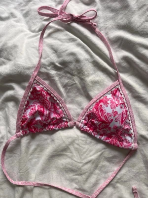 Rosa och vit bikiniöverdel med mönster - Snygg trekantsbikini från shein i vitt och rosa med mönster. Knyt i nacke och rygg, samt tunna band. Perfekt nu till sommaren