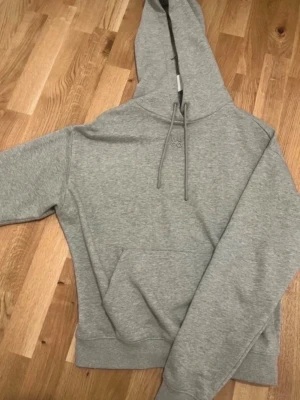 Hugo Boss Hoodie XS - Grå HUGO hoodie med broderad logotyp framtill och en praktisk ficka på magen. Hoodien har en avslappnad passform och justerbara dragsko.  Köpt på zalando för 1 495 kr Använd ett fåtal gånger och är i perfekt skick  Material: 100% bomull Luva och känguruficka  #hugo #hugoboss #hugobosswoman  För snabbare leverans – välj gärna annat fraktsätt än PostNord. <3