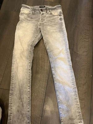 Gråa jeans från Jack and Jones - Snygga grå skinny jeans från Jack and Jones. Jeansen har en ljusgrå färg och smal passform som sitter tajt längs benen. Perfekta för en trendig och avslappnad stil.