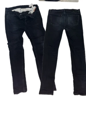 Svarta skinny jeans från Acne Studios - Svarta skinny jeans från Acne Studios med klassisk femficksdesign och smal passform. Jeansen är tillverkade i bomull med lite elastan för stretch och komfort. Perfekta för en stilren och modern look.