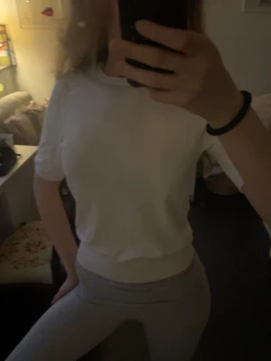 Vit kortärmad topp från Vero Moda - Säljer en enkel och stilren vit topp från Vero Moda. Toppen har korta ärmar, rund halsringning och är gjord i ett mjukt, tunt stickat material. Perfekt att matcha med jeans eller kjol för en clean look.
